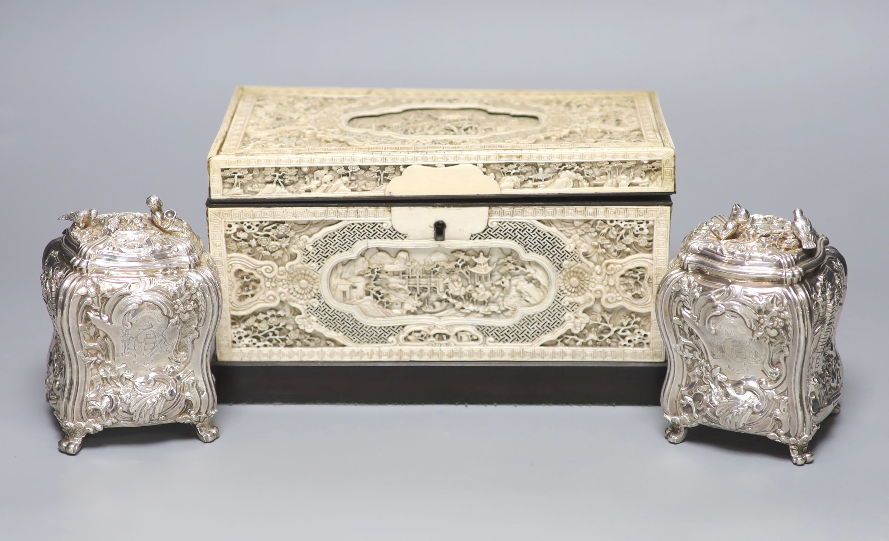 A good pair of George II embossed silver tea caddies and covers, by Elizabeth Godfrey, London, 1749/50, housed in a later 19th century pierced Canton ivory mounted caddy, with velvet interior